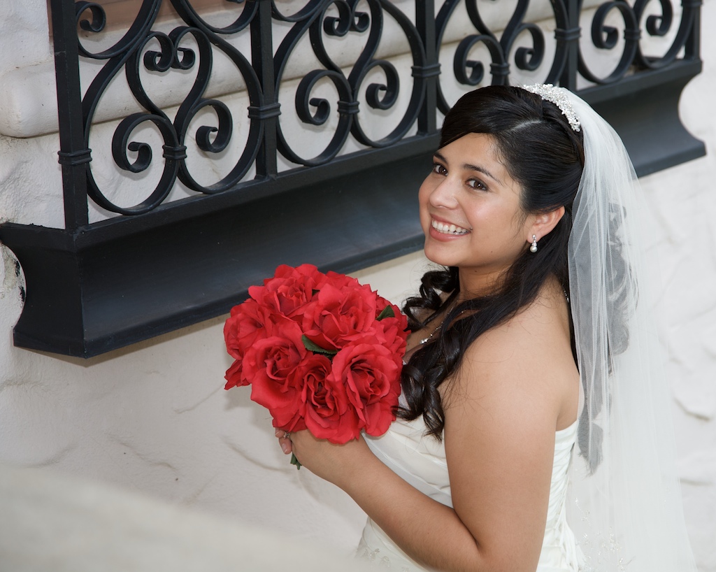 Beautiful bride by wrought iron window