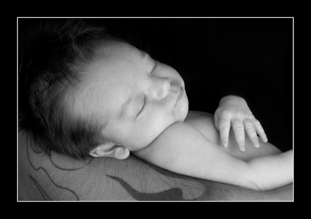 B/W Image of beautiful newborn baby boy in his daddy's arms